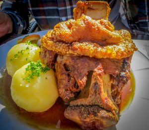 Portion Schweinehaxe med potatis.