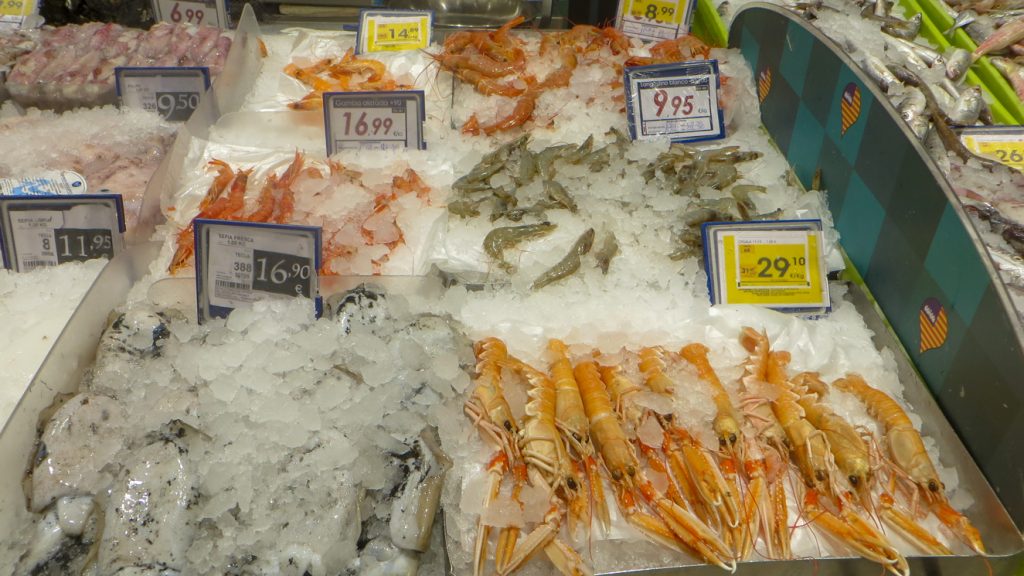 Affärens fiskdisk med skaldjur och bläckfisk på is.