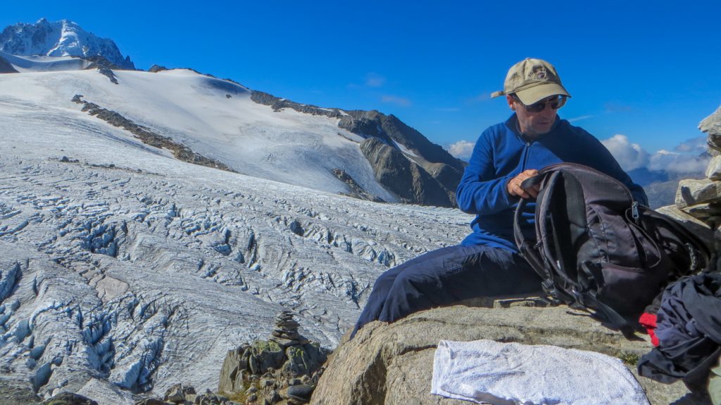 Ryggsäck packas upp till lunch bredvid en glaciär.