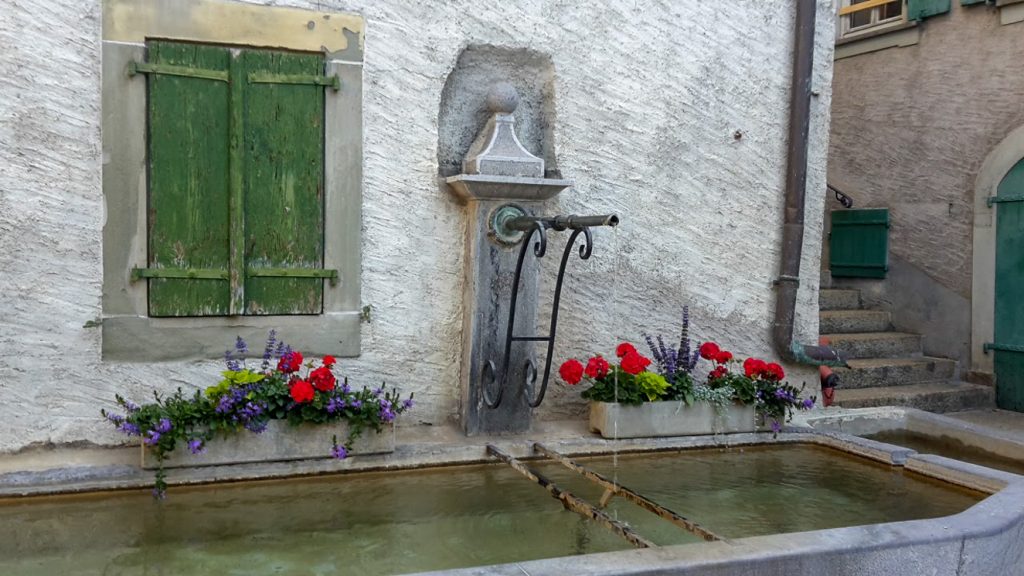 Vattenbrunn i liten stad vid Genèsjön