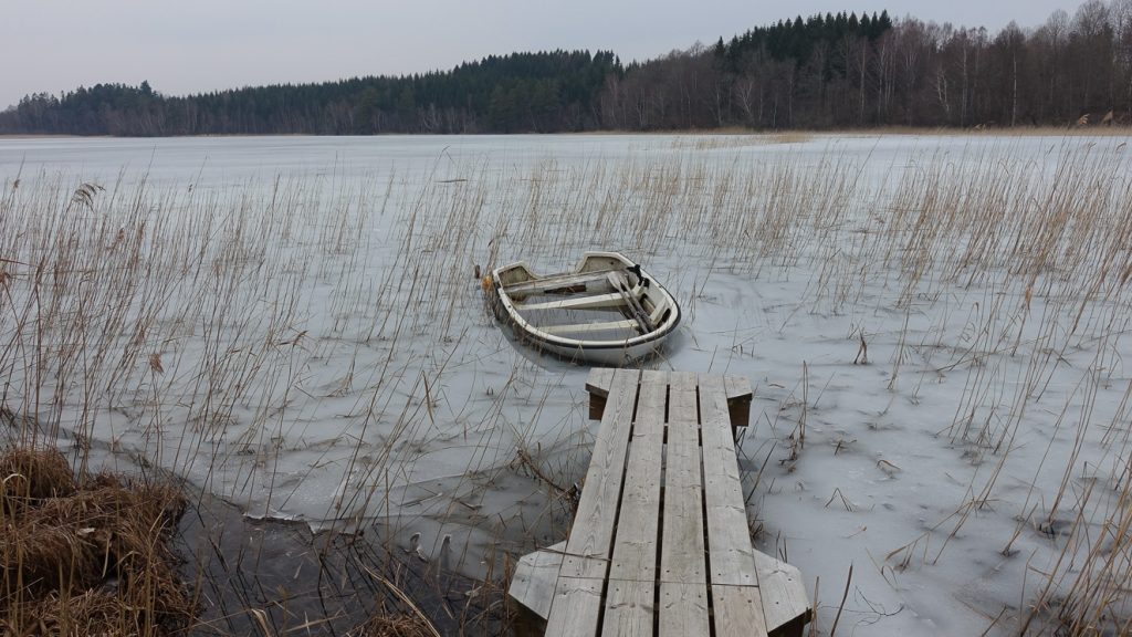 Flämsjön med båt fastfrusen i isen